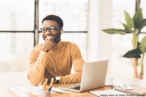 Happy man at desk thinking