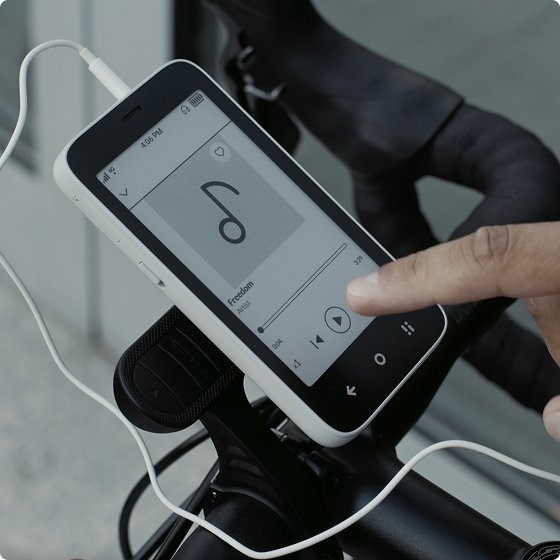 A person listens to music on a Mudita Kompakt (life with ease) phone.