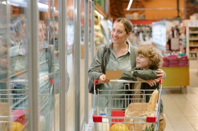 Woman shopping in grocery store with her son