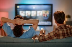 Couple watching TV amidst Netflix / Paramount bidding war for Warner Brothers Discovery