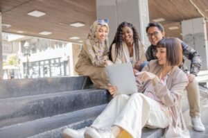 Young adults gather around a tablet, reflecting how digital habits and social influence are reshaping Gen Z consumer behavior.