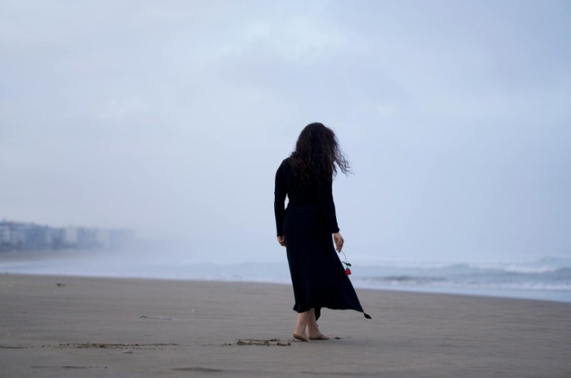 A lone woman walks along a quiet beach following a deadly shooting that left Sydney, Australia in mourning.
