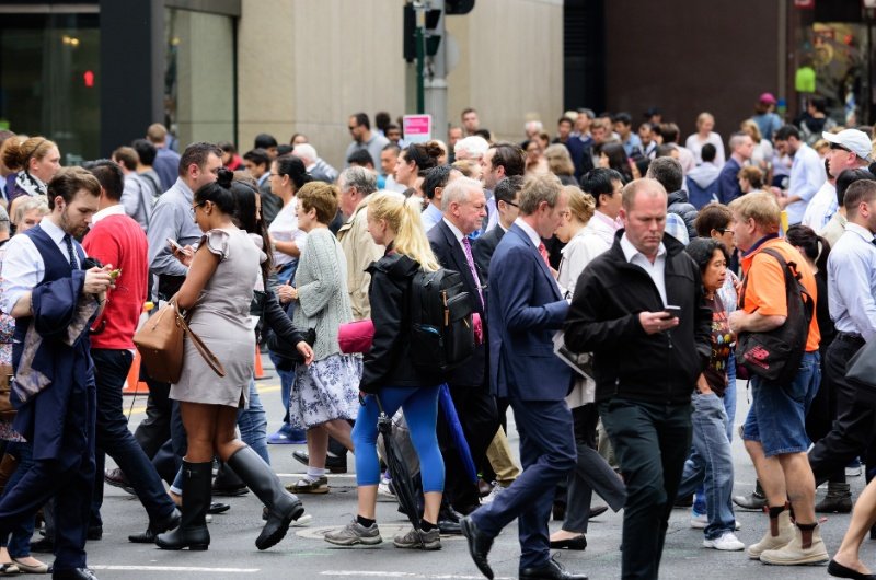 Workers move through a busy city street as new data shows U.S. unemployment rising to its highest level in four years.