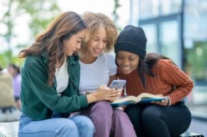 Teen students view social media on smartphone.