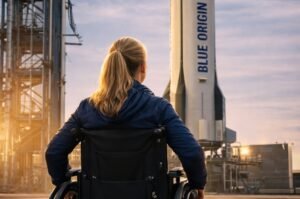 A woman in a wheelchair looks up at the Blue Origin rocket ahead of the historic accessibility-focused flight.