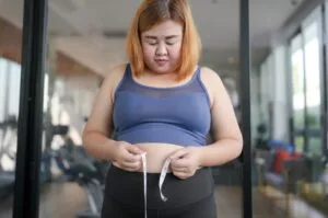 Woman measures her waist.