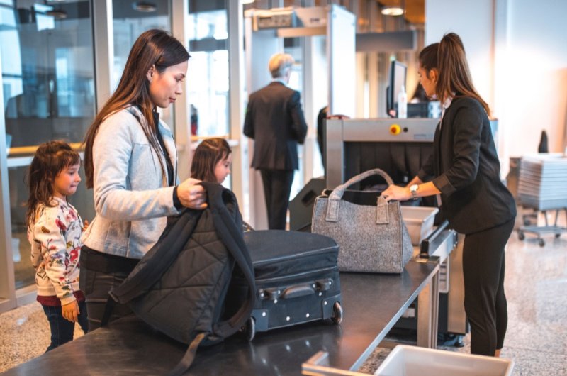 Woman at airport security with daughter