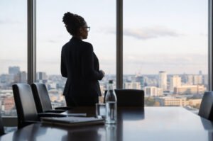 Woman overlooking cityscape at sunset.