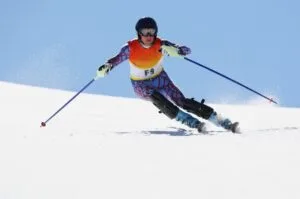 An alpine skier speeds down the slopes as competition unfolds at the 2026 Winter Olympics in Italy.