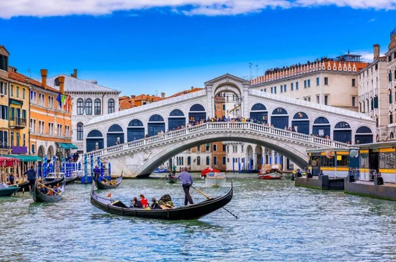 A gondola passes beneath Venice’s iconic Rialto Bridge, capturing the timeless beauty and everyday rhythm of life along the city’s historic canals.