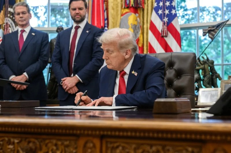 President Donald Trump signs an executive order as the administration moves to expand access to retirement savings through the new TrumpIRA platform.