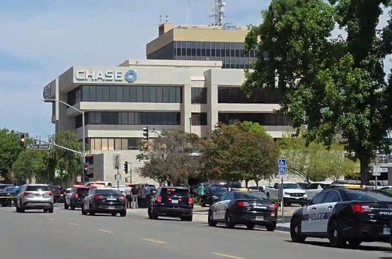 Police and emergency vehicles remain positioned near downtown Bakersfield as authorities continue negotiations in an ongoing hostage standoff that began Tuesday.