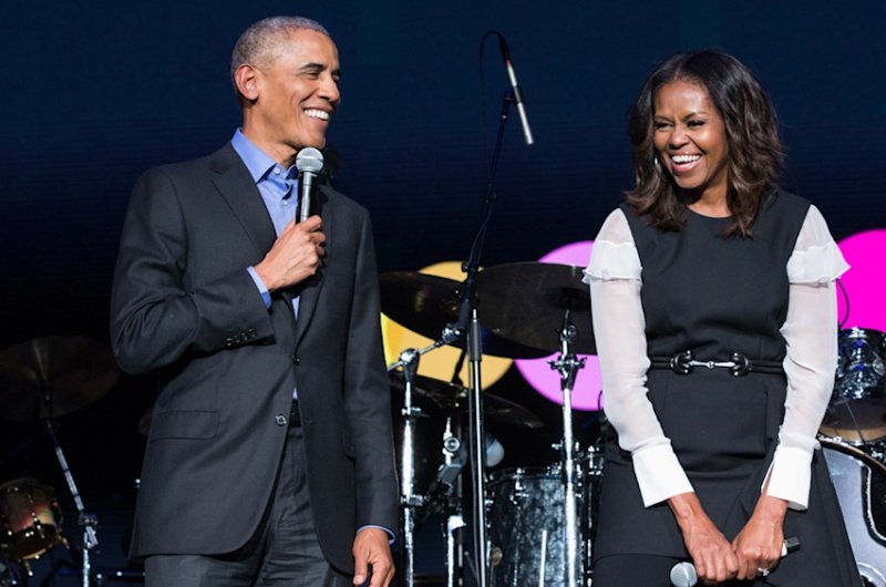 Former President Barack Obama and former First Lady Michelle Obama take the stage at a live event, microphones in hand, ahead of the grand opening of the Obama Presidential Center on June 18, 2026.