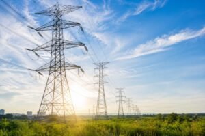 High-voltage transmission lines carry electricity across the grid as growing AI data center demand drives new investment in energy infrastructure and power generation.