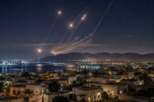 Missile and air-defense trails light up the night sky above a coastal city in southern Iran following the latest U.S. military attack, as tensions between the United States and Iran continue to escalate.