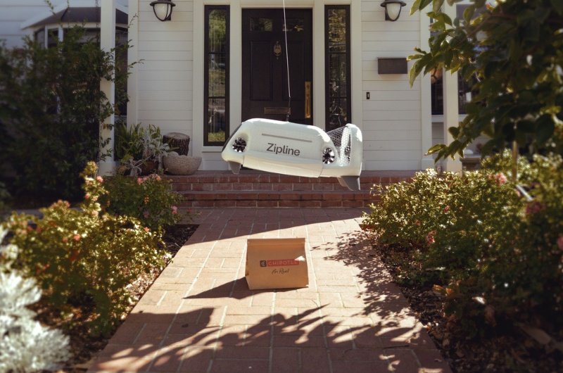 A Zipline delivery drone lowers a food order directly to a customer's home without landing.