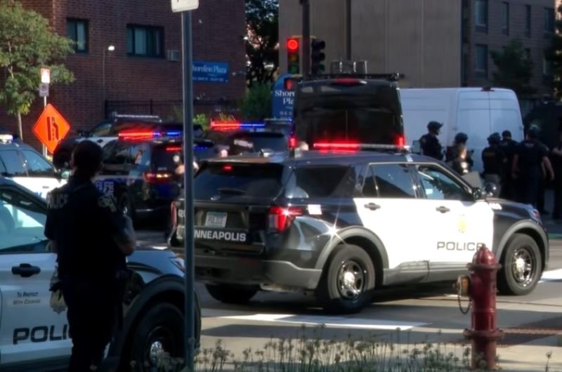 Minneapolis police respond to the scene of a deadly shooting at a downtown apartment building Wednesday, where two people were killed and six others were injured, including three police officers.