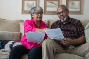 A retired couple reviews financial documents at home as lawmakers debate how to protect Social Security benefits and address the program’s approaching funding shortfall.